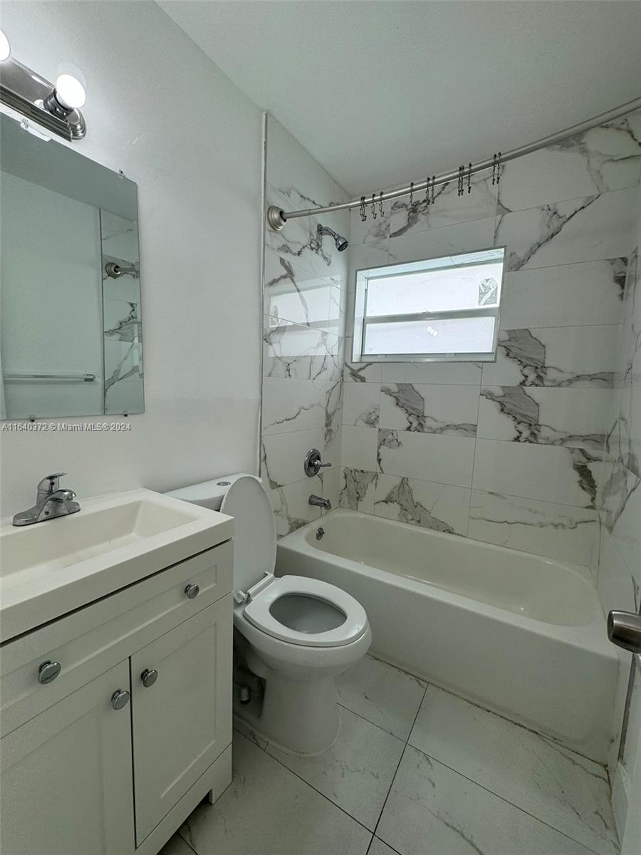 2150 Northwest 24th Street Miami, FL 33142 - Photo 18 of 18 a bathroom with a granite countertop sink a toilet and shower