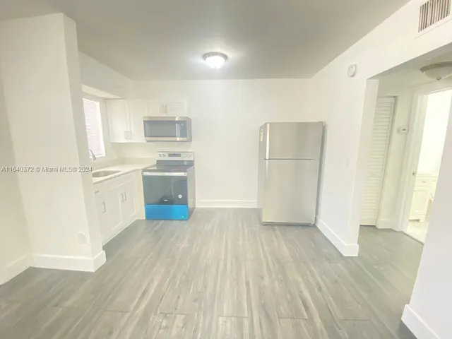 a kitchen with a sink a refrigerator and a stove top oven