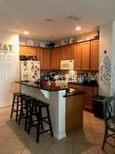 a kitchen with kitchen island granite countertop a table chairs sink and cabinets