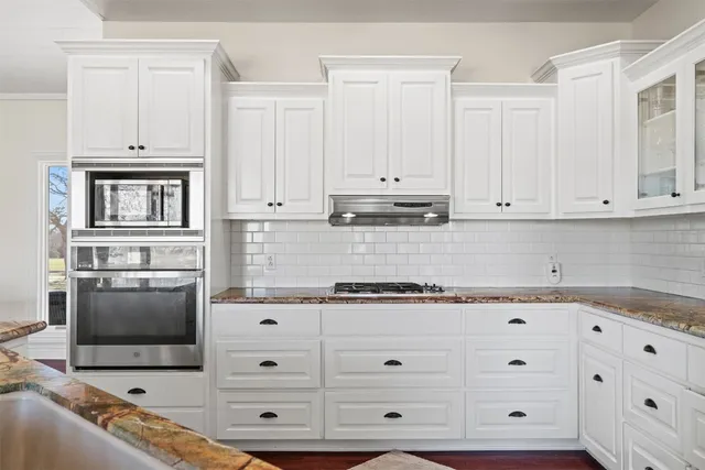 a kitchen with stainless steel appliances granite countertop a sink and a stove