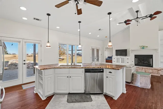 a kitchen with a sink a counter top space stainless steel appliances and wooden floor