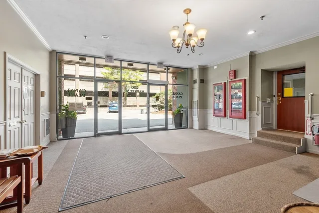a spacious bedroom with a large bed and a chandelier