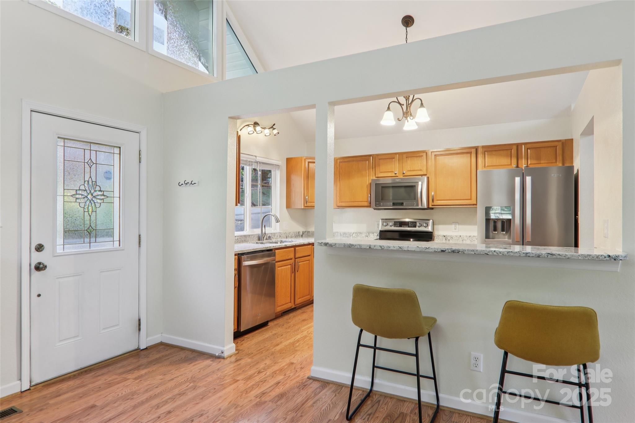 166 Linsonwood Ridge Waynesville, NC 28786 - Photo 11 of 39 a kitchen with stainless steel appliances granite countertop a stove a sink dishwasher and a refrigerator with wooden floor