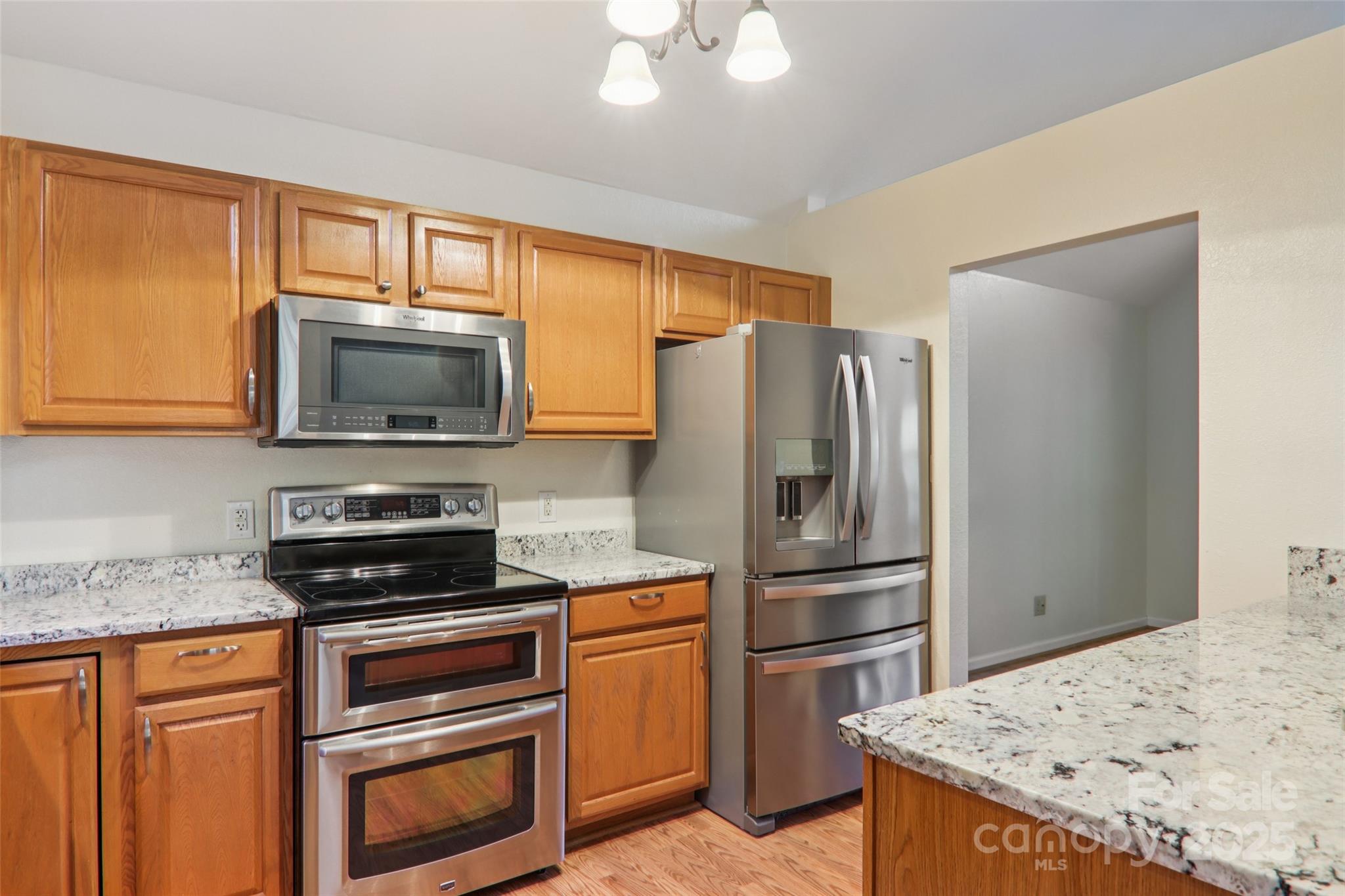 166 Linsonwood Ridge Waynesville, NC 28786 - Photo 14 of 39 a kitchen with granite countertop a refrigerator stove and microwave