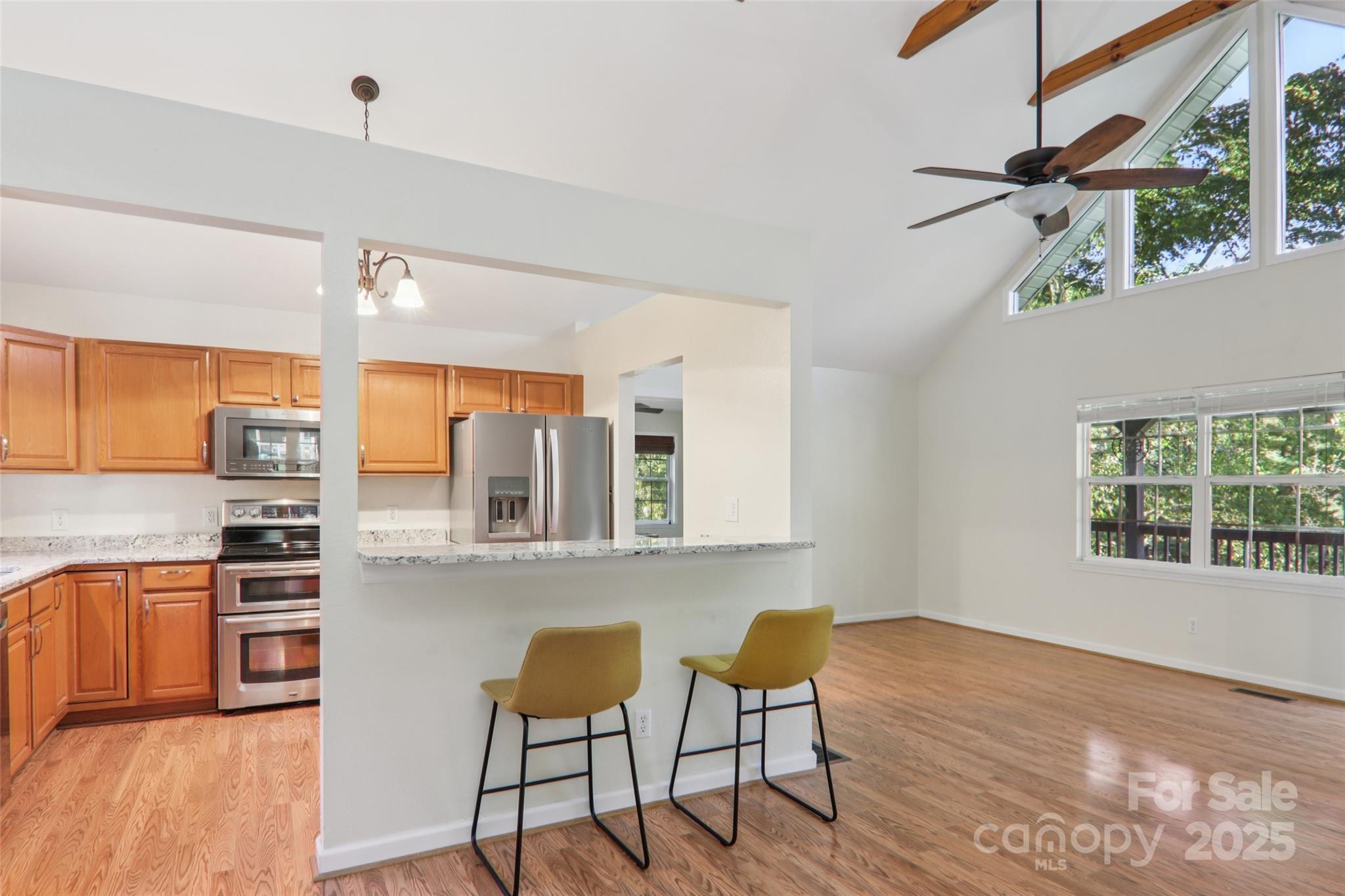 166 Linsonwood Ridge Waynesville, NC 28786 - Photo 10 of 39 a kitchen with stainless steel appliances wooden floor and dining table chairs