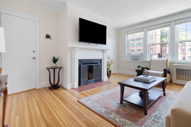 a living room with furniture a fireplace and a flat screen tv