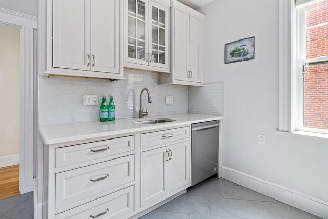 a kitchen with stainless steel appliances white cabinets and a window
