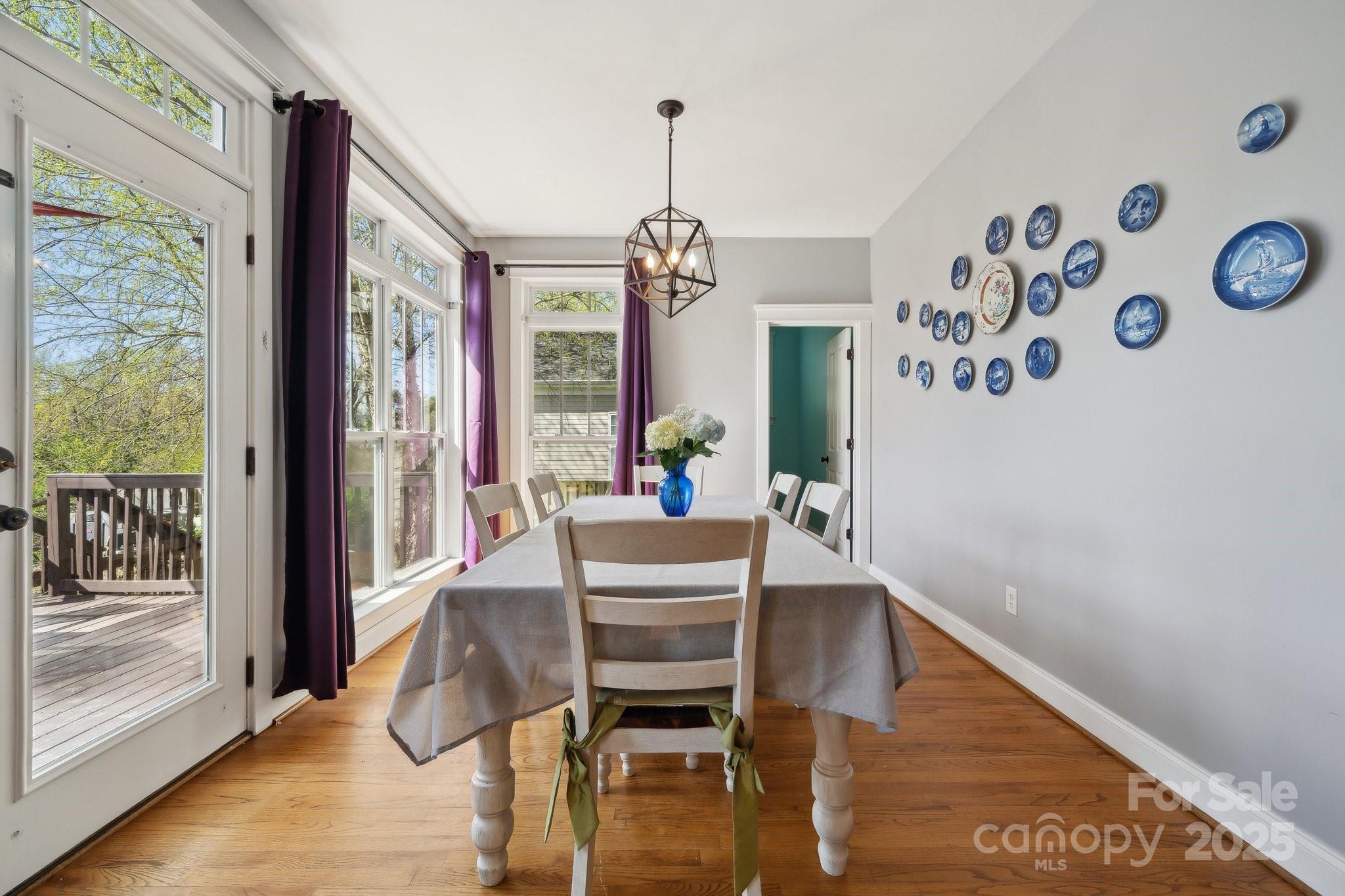 369 Shoreline Parkway Tega Cay, SC 29708 - Photo 12 of 40 a dining room with wooden floor and a chandelier