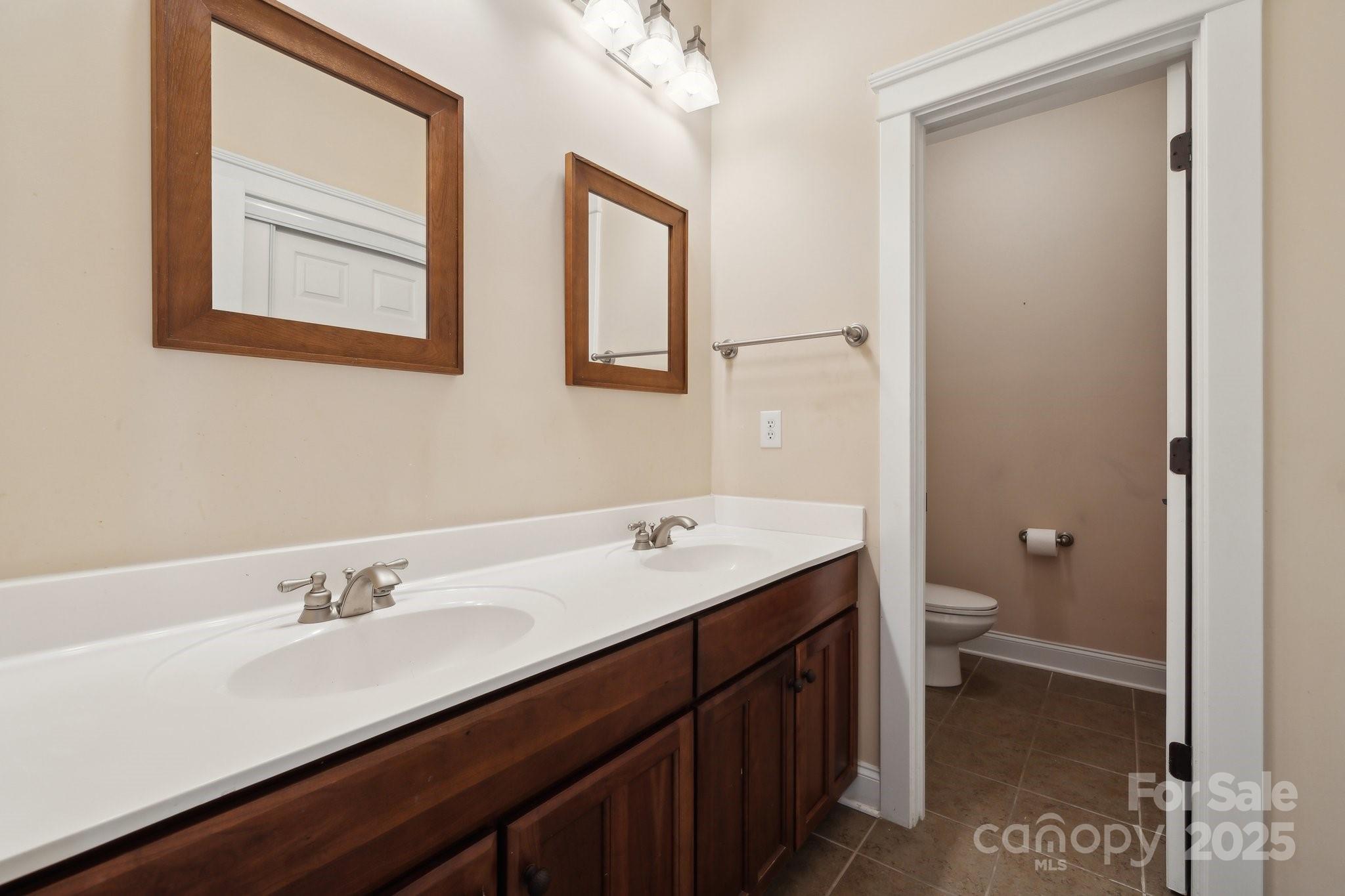 369 Shoreline Parkway Tega Cay, SC 29708 - Photo 24 of 40 a bathroom with a granite countertop sink a toilet and a mirror