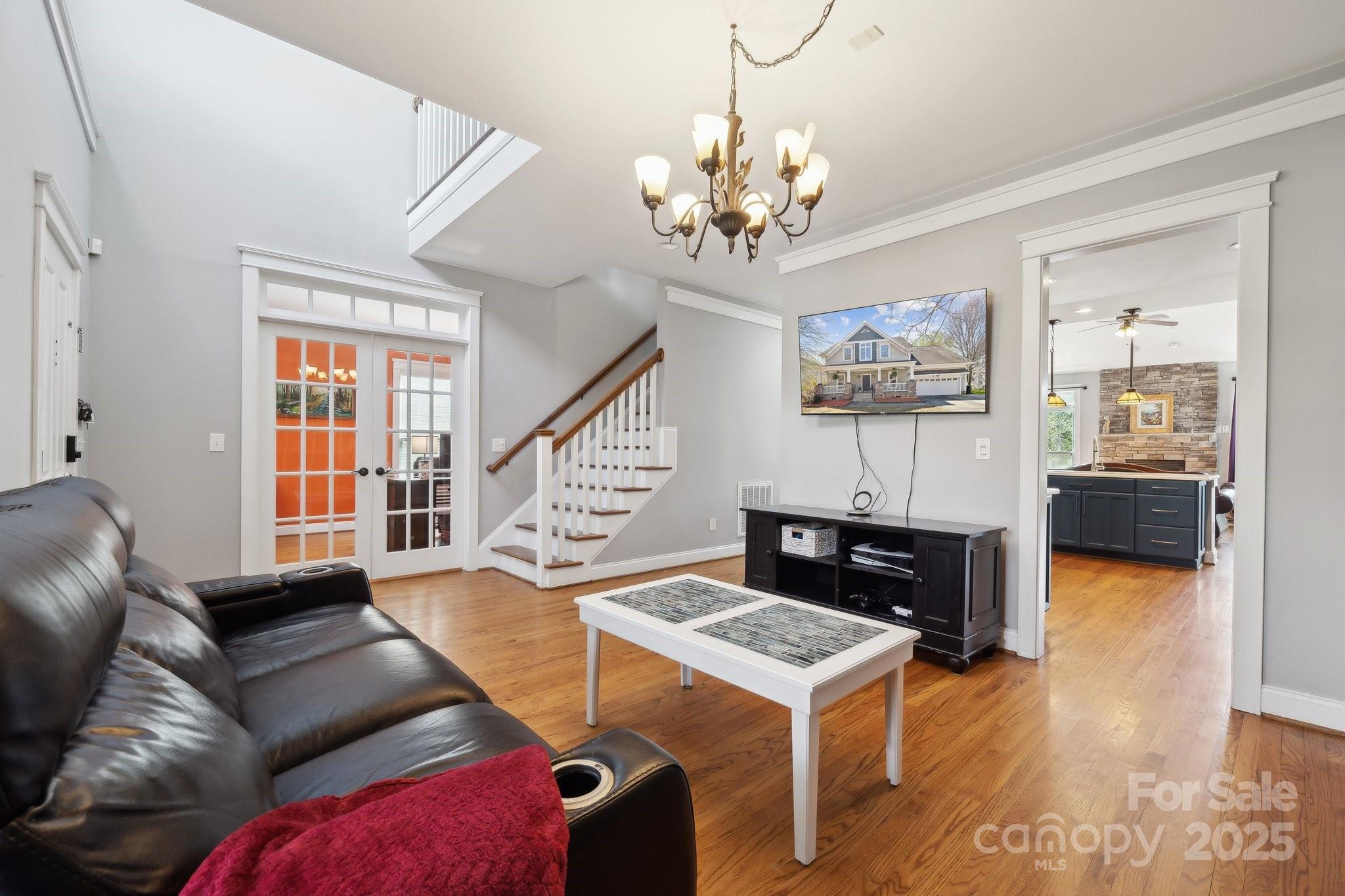 369 Shoreline Parkway Tega Cay, SC 29708 - Photo 5 of 40 a living room with furniture a chandelier and a fireplace