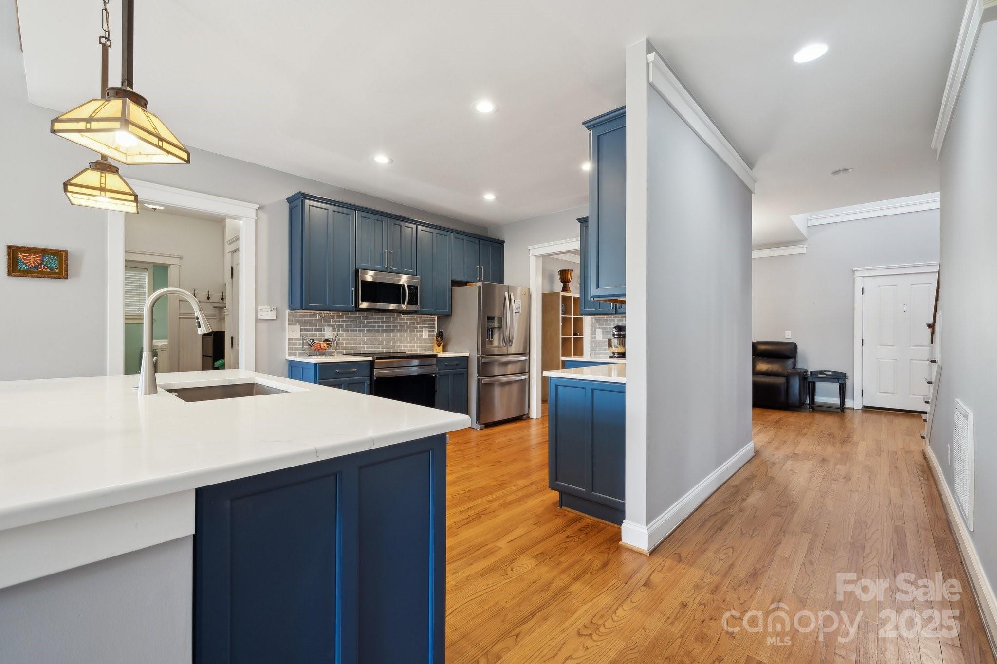 369 Shoreline Parkway Tega Cay, SC 29708 - Photo 6 of 40 a large kitchen with sink a counter top space stainless steel appliances and a chandelier