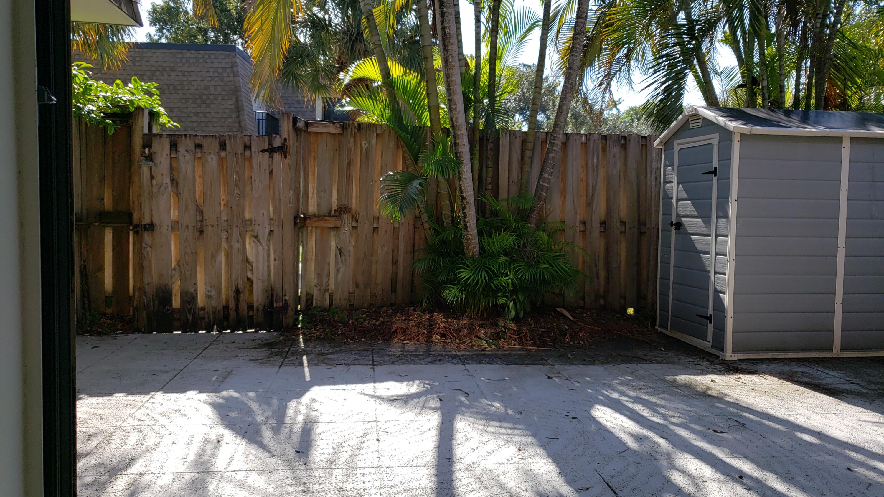 2913 Southwest 22nd Circle, Unit 36D Delray Beach, FL 33445 - Photo 27 of 33 a view of backyard with potted plants and wooden fence