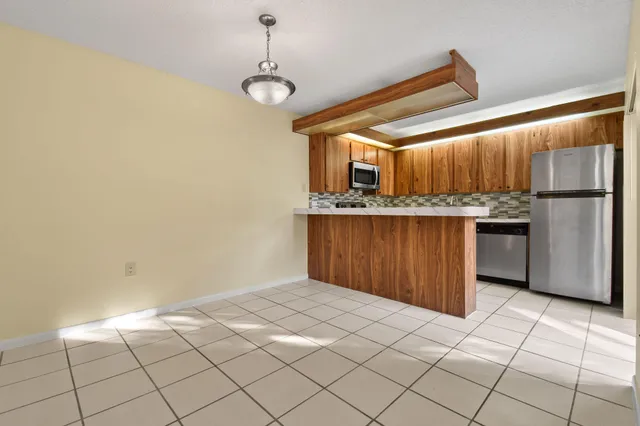 a kitchen with a wooden floor and a refrigerator