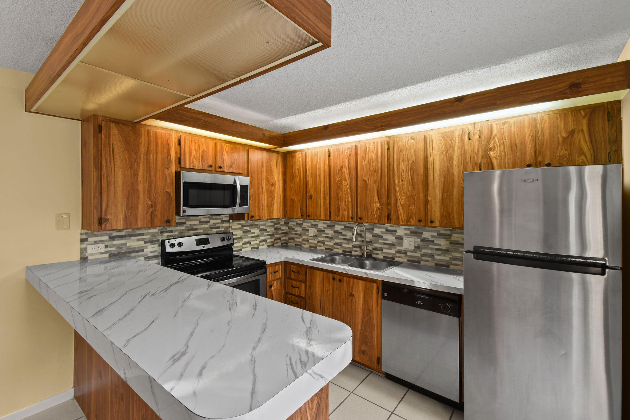 2913 Southwest 22nd Circle, Unit 36D Delray Beach, FL 33445 - Photo 8 of 33 a kitchen with stainless steel appliances granite countertop a sink stove and refrigerator