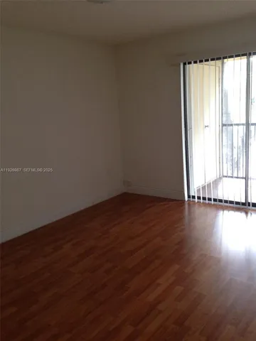 a view of a room with wooden floor and windows