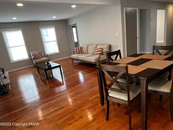 a living room with furniture and a wooden floor