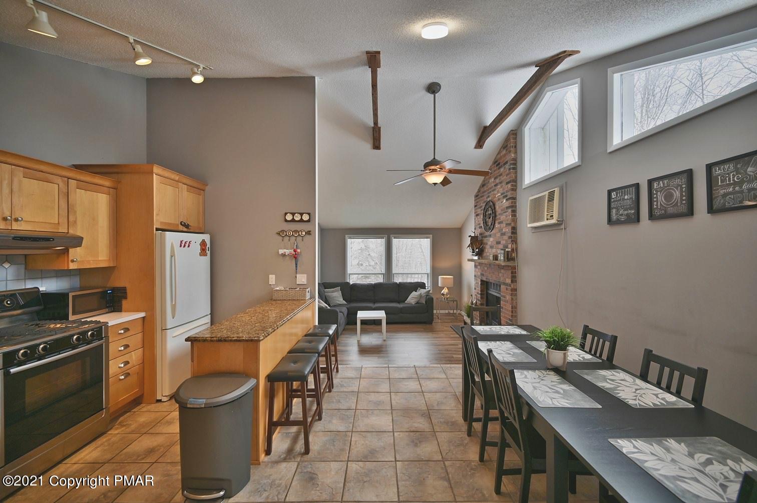 213 Boulder Road Lake Ariel, PA 18436 - Photo 22 of 78 a open kitchen with stainless steel appliances granite countertop a stove a refrigerator a kitchen island a dining table and chairs with wooden floor