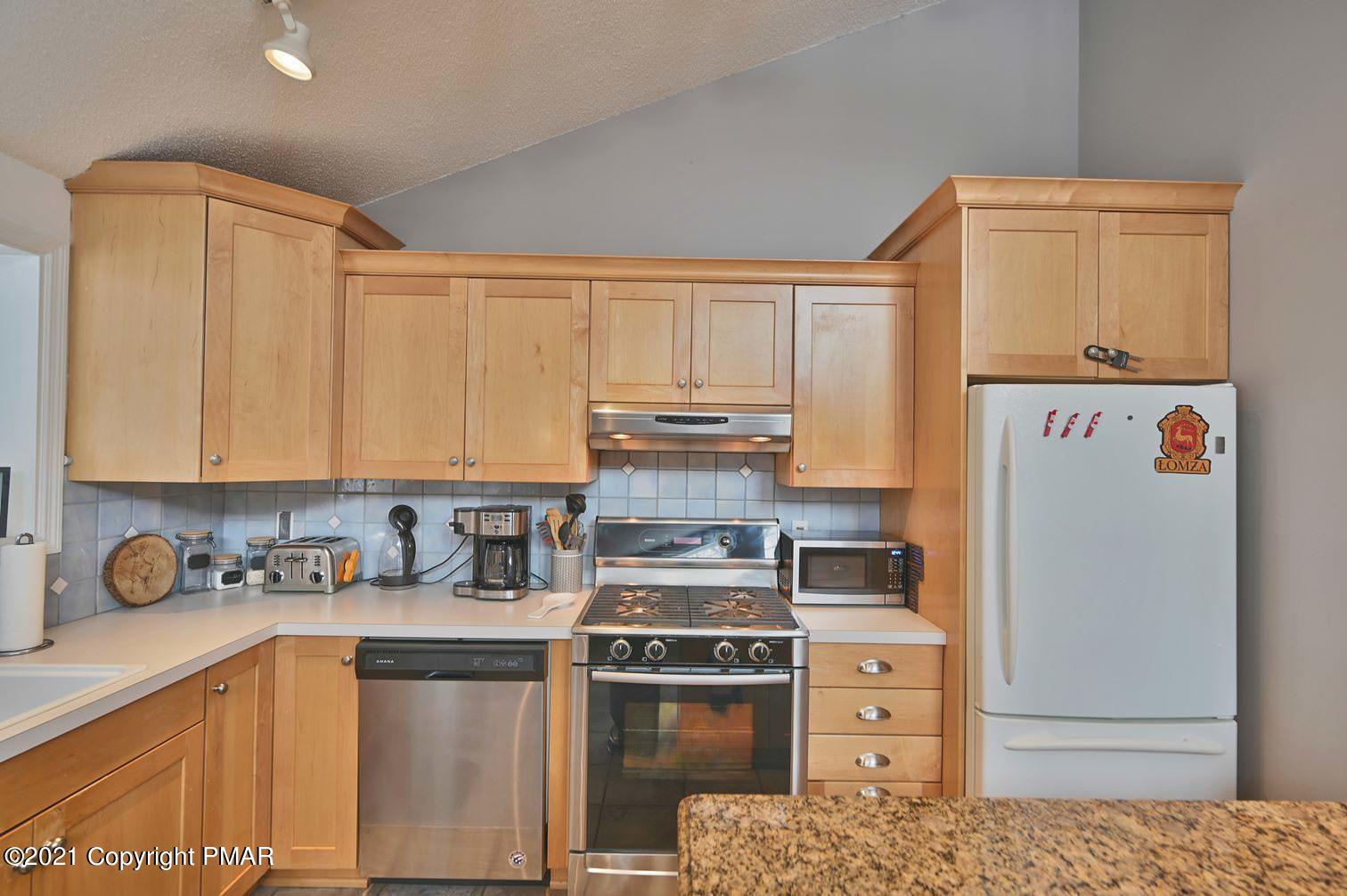 213 Boulder Road Lake Ariel, PA 18436 - Photo 24 of 78 a kitchen with stainless steel appliances granite countertop a stove a refrigerator and a white cabinets