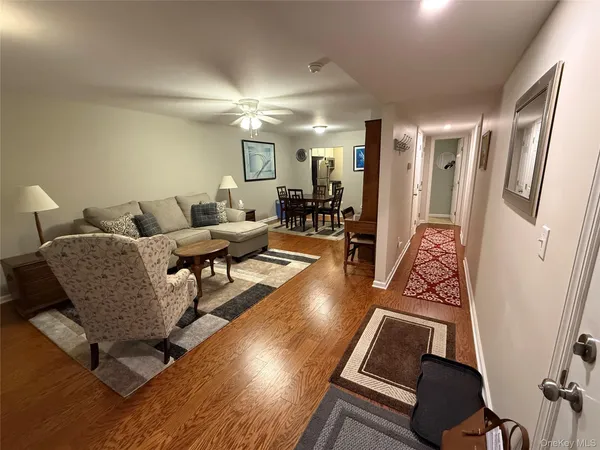 a living room with couches and a large mirror next to a window