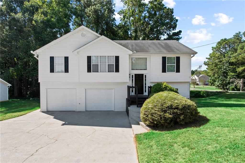 687 Wesley Chapel Road Villa Rica, GA 30180 - Photo 1 of 1 a view of a white house next to a yard with big trees