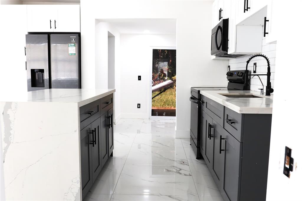 3075 Northwest 68th Street Miami, FL 33147 - Photo 24 of 24 a kitchen with stainless steel appliances a sink stove and refrigerator