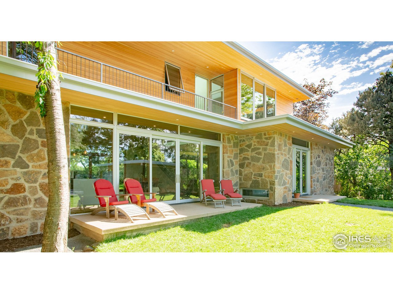 3074 15th Street Boulder, CO 80304 - Photo 4 of 40 a view of a swimming pool with red chairs in front of house