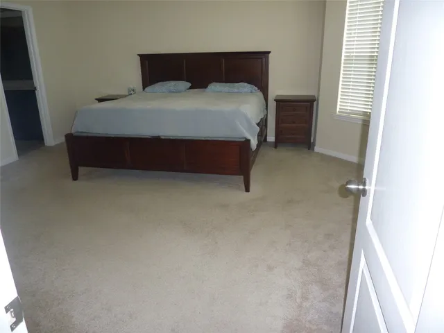 a bed sitting in a bedroom next to a window