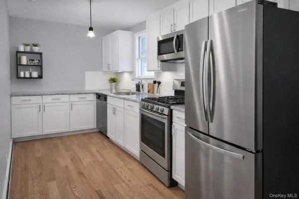 a kitchen with stainless steel appliances a refrigerator sink and microwave
