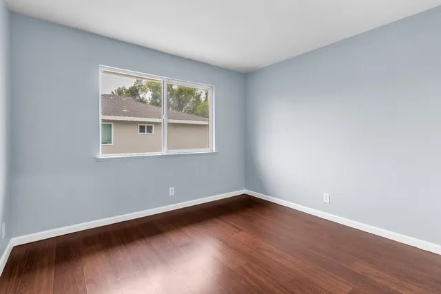 a view of a room with wooden floor and window