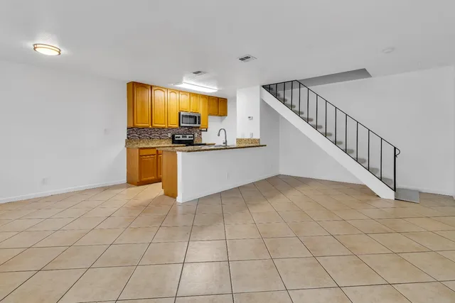 a view of a kitchen with kitchen island granite countertop lots of white stainless steel appliances