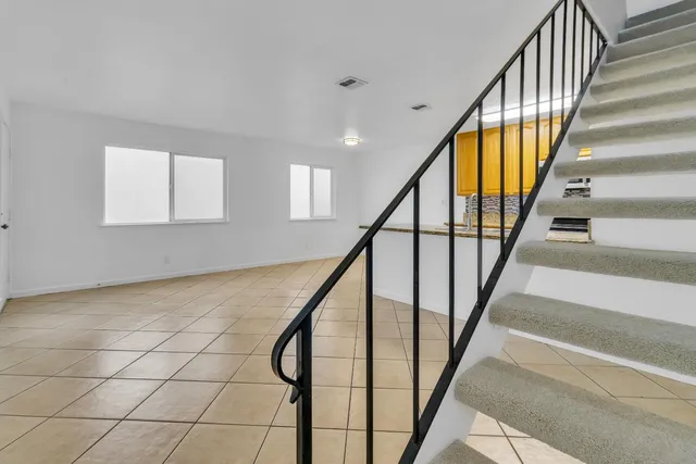 a view of staircase with railing and white walls