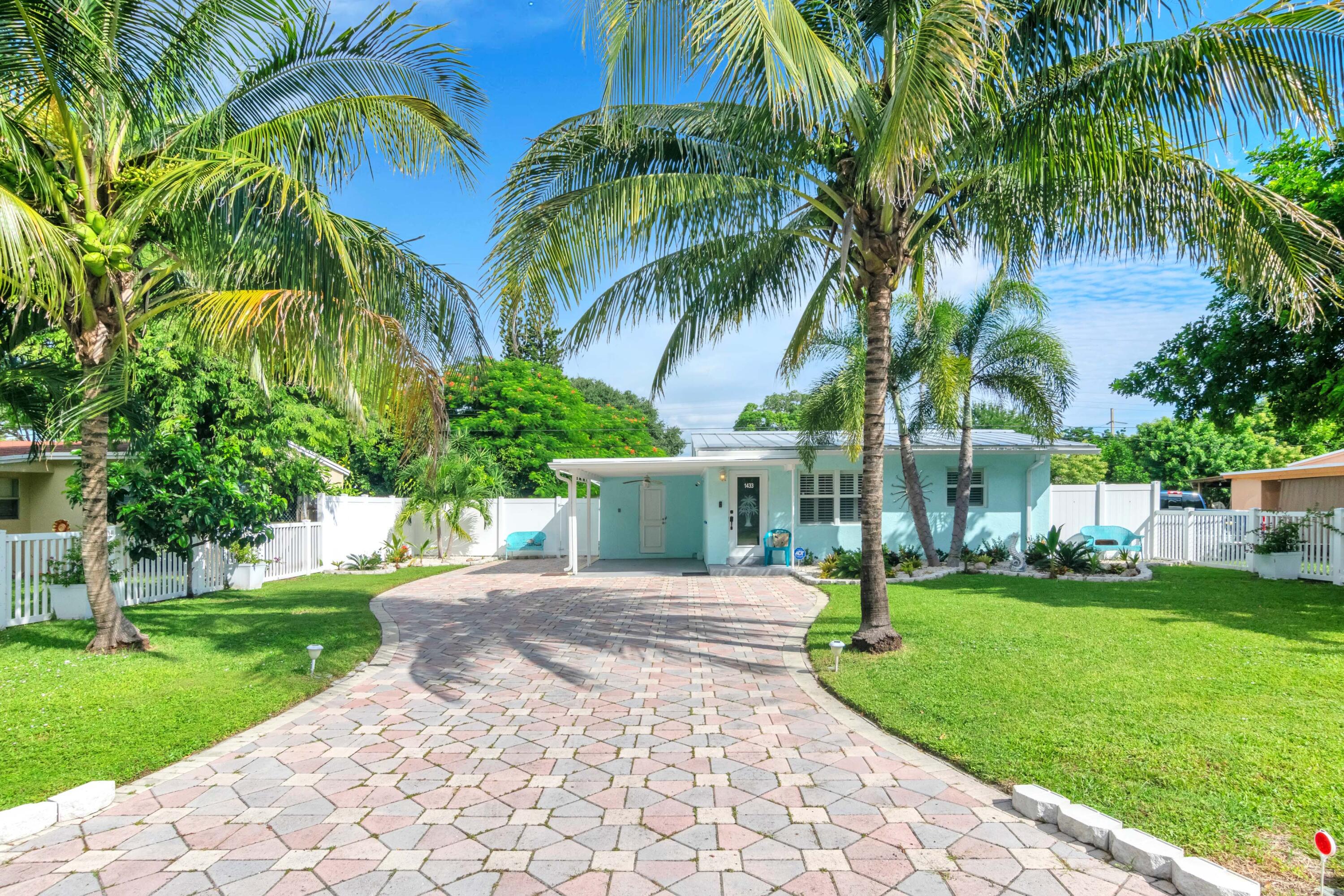 1433 Northeast 27th Street Pompano Beach, FL 33064 - Photo 14 of 17 a view of a house with a yard and palm trees
