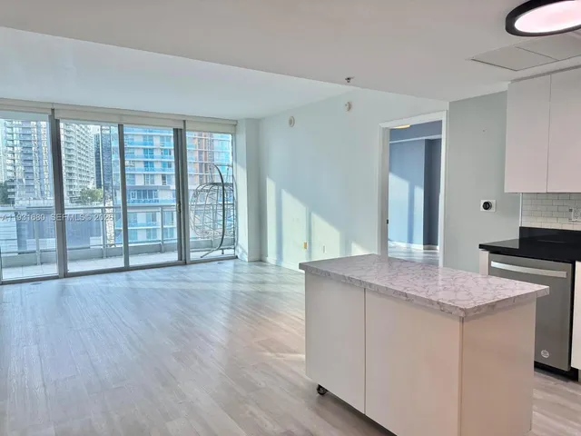 a kitchen with stainless steel appliances a refrigerator a sink and wooden floors