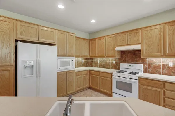 a kitchen with cabinets appliances and a window