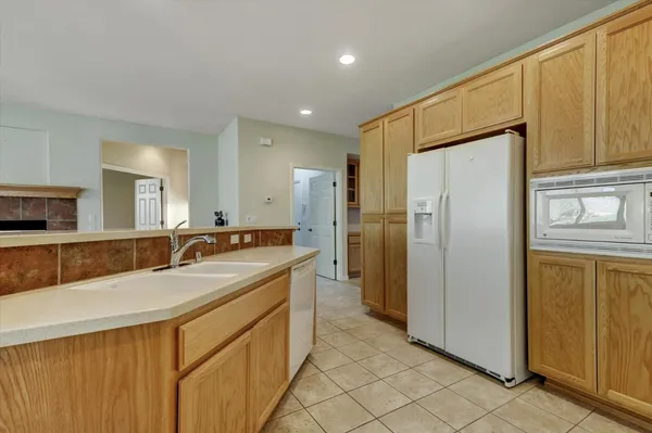 a large kitchen with a refrigerator a sink and dishwasher