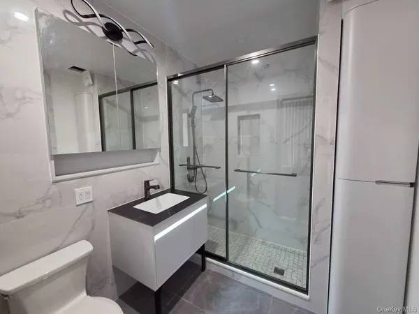 a bathroom with a granite countertop sink mirror and a shower
