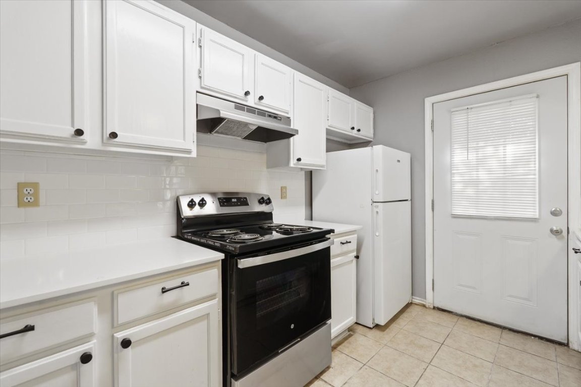 23393 Nameless Road, Unit 156 Leander, TX 78641 - Photo 8 of 21 a kitchen with stainless steel appliances white cabinets and a refrigerator