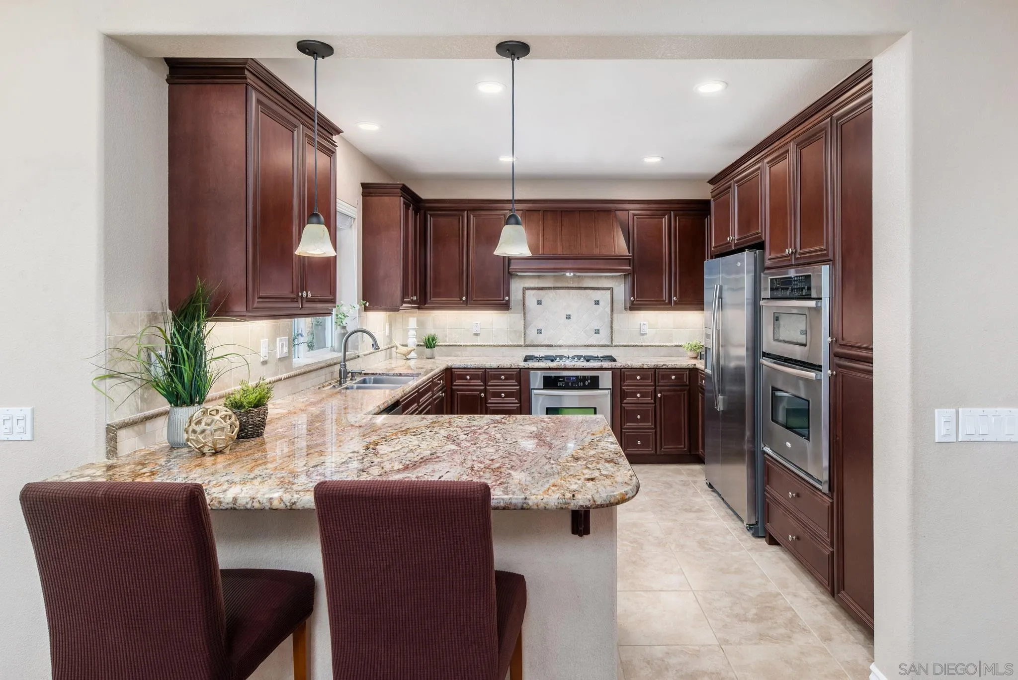 650 Liquid Amber Way San Marcos, CA 92078 - Photo 15 of 48 a kitchen with granite countertop a table chairs microwave and refrigerator
