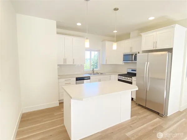 a kitchen with a refrigerator a sink and a microwave