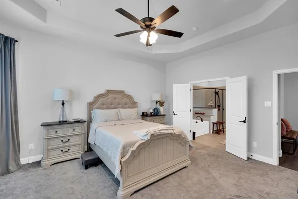 a spacious bedroom with a bed and a chandelier