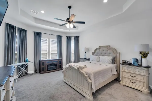 a bedroom with a large bed and a chandelier