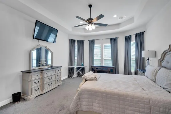 a bedroom with a bed a window and dresser