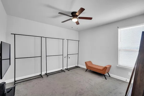 a living room with furniture and a ceiling fan