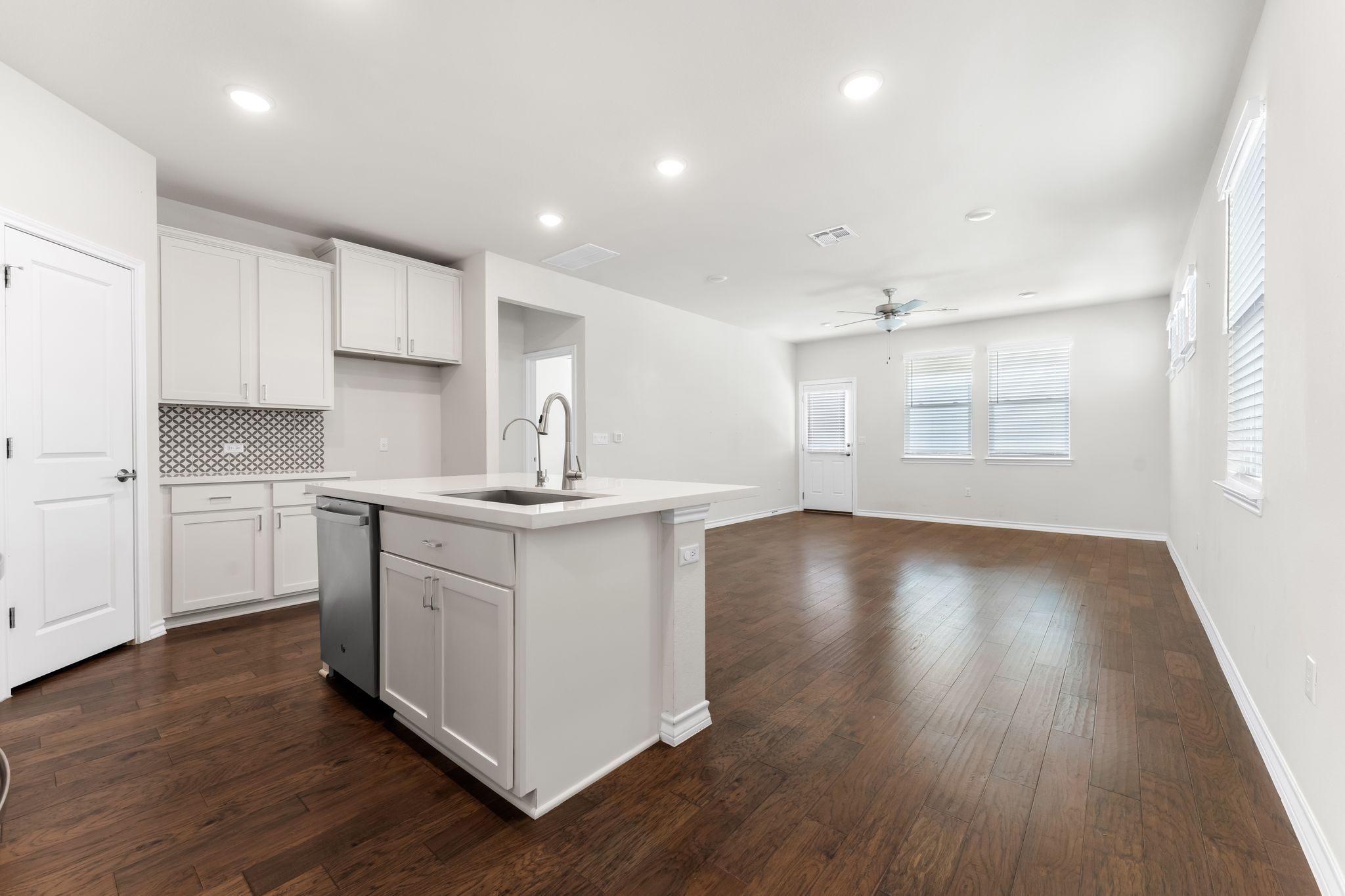 2803 Mary Elizabeth Drive Austin, TX 78728 - Photo 30 of 30 Kitchen featuring white cabinets, a kitchen island with sink, dark wood-style floors, open floor plan, and recessed lighting