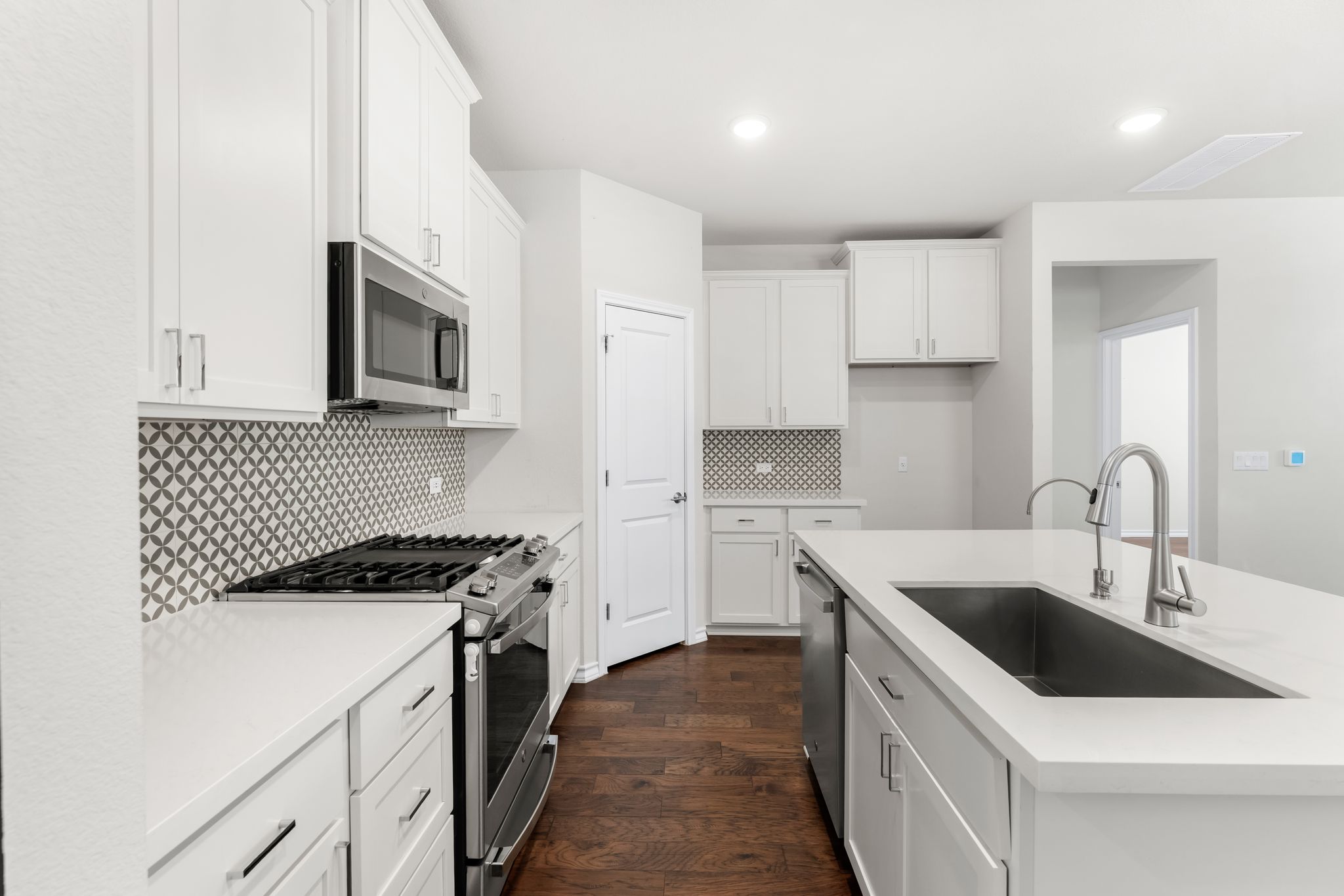 2803 Mary Elizabeth Drive Austin, TX 78728 - Photo 5 of 30 Kitchen featuring stainless steel appliances, white cabinetry, dark wood-style flooring, backsplash, and recessed lighting