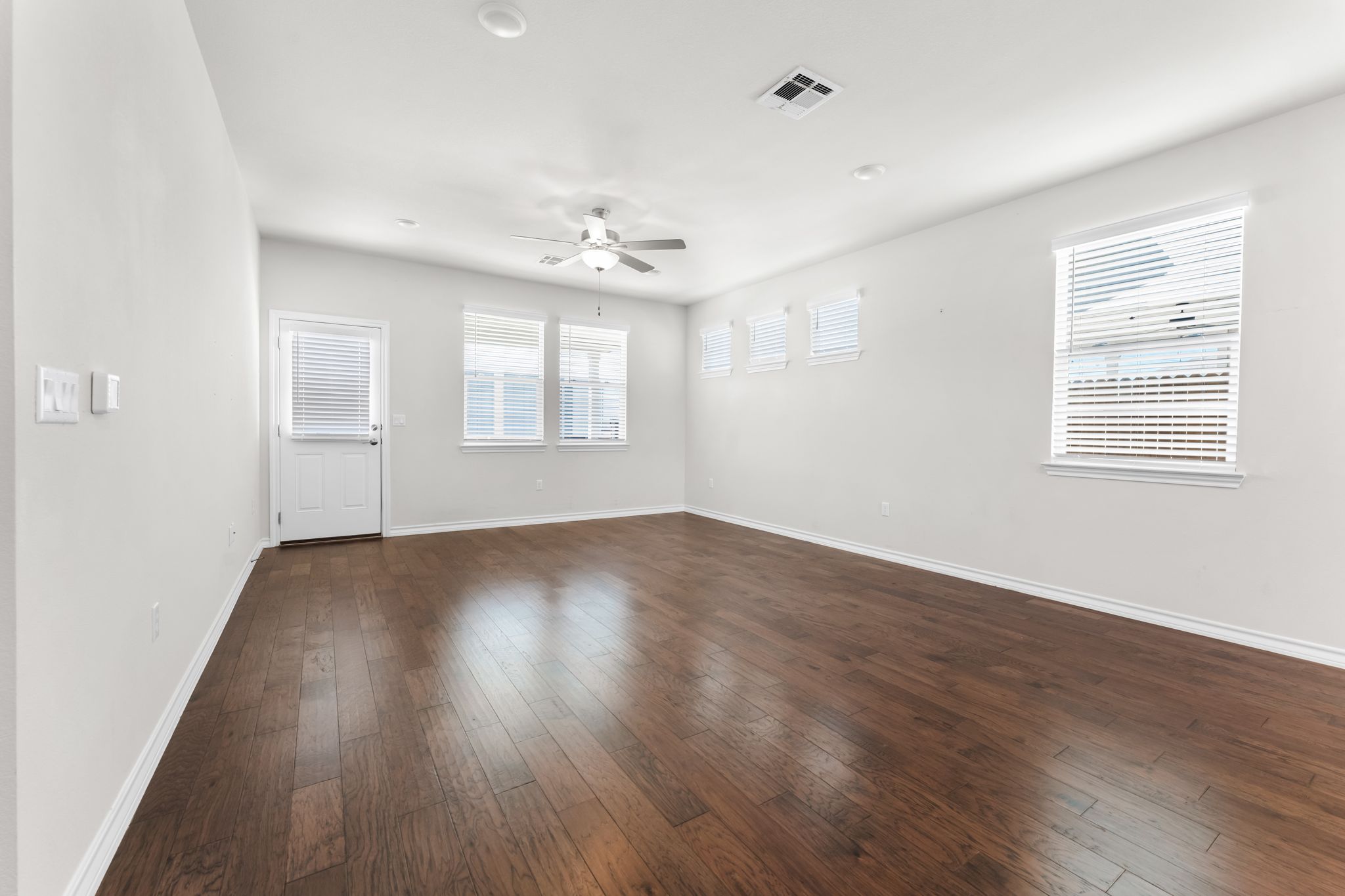 2803 Mary Elizabeth Drive Austin, TX 78728 - Photo 9 of 30 Empty room with dark wood-style floors, a ceiling fan, and plenty of natural light