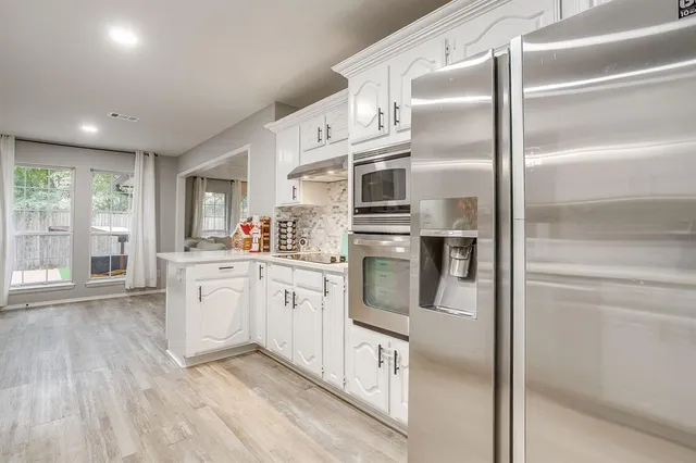 a kitchen with stainless steel appliances kitchen island granite countertop a stove a sink and a refrigerator