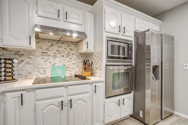 a kitchen with granite countertop a refrigerator and a sink