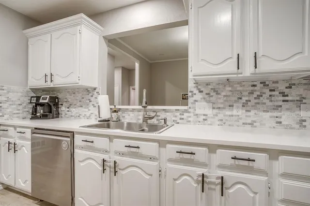 a kitchen with cabinets appliances a sink and a counter top space