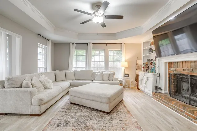 a living room with furniture a fireplace and a large window